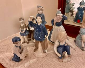 Vintage porcelain figurines, fisherman, and children wearing blue and white