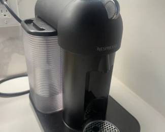 Nespresso Machine
Price: $140.00
Condition: Good
Black Nespresso capsule coffee machine with chrome top/front detail and a separate clear ribbed pod-storage drawer attached or placed beneath it. Some pods included