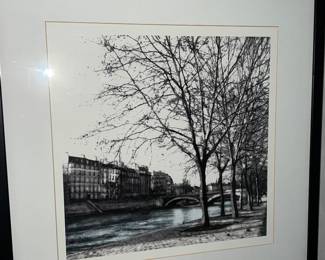Black and white artwork of a scenic riverside cityscape