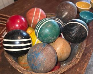 collection of vintage wooden croquet balls featuring worn painted finishes and ribbed stripe patterns