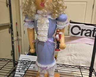 Nutcracker Clara doll figure, curly blonde hair, holding mini nutcracker