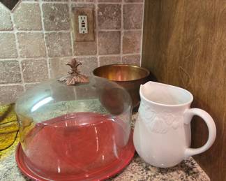 Cake dome with red plate, brass bowl, white pitcher