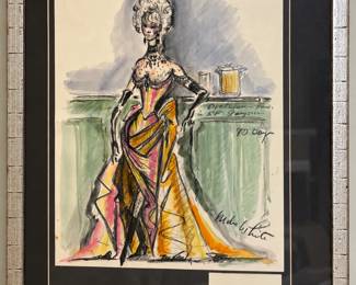 Colorful framed costume illustration with a large feathered headdress and an identifying Miles White and Marlene Dietrich display card