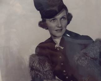 Vintage black and white costume portrait of a woman wearing a structured hat and tailored outfit