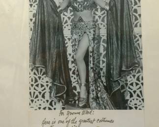 Vintage photograph of an elaborate fantasy costume with a handwritten dedication beneath the image