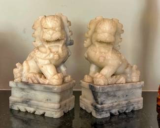 Pair of pale carved guardian lion figures on stepped stone bases from the Tom Culver estate
