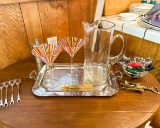 Vintage barware grouping with a glass pitcher striped cocktail glasses metal tray and serving accessories