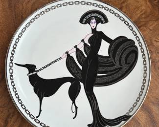 White decorative plate with a stylized black fashion figure and dog design