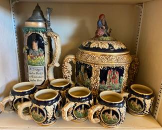 Vintage German Castle Punch Bowl Set | Old World Stoneware | Made in Germany-mint condition $100 mid-late 20th century. This impressive vintage German punch bowl set brings old-world charm straight to the table. Featuring a large lidded bowl and five matching handled cups, each piece is richly decorated with raised castle scenes, grape clusters, and scrolling vine details in classic cream, cobalt, and earthy tones. Whether styled as a centerpiece, used for special gatherings, or displayed as European décor, this set has undeniable presence. Heavy, ornate, and beautifully detailed