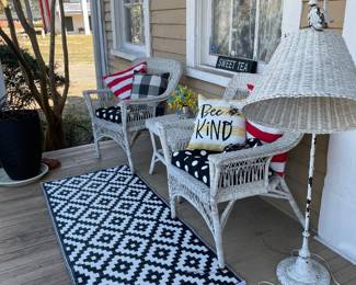 Front porch of Mon Chalet with white wicker pole lamp