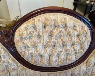 Walnut Victorian parlor sofa showing tuffed rounded back and accents 