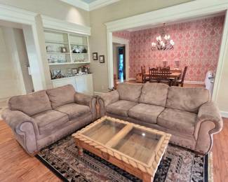Tan brown upholstered nailhead couch and loveseat. Rustic wooden Texas star carved coffee table with glass lift top for storage/display