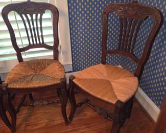 Antique French Provençal style wooden carved dining room chairs. Floral basket carving turned legs with woven rush seats