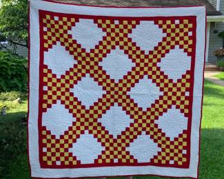 Vibrant yellows and reds with white blocks enhances this quilt.