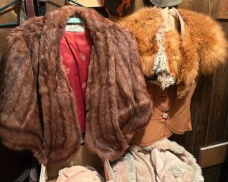 Vintage Fur Stoles — Mink and Red Fox Two vintage fur stoles: a brown mink-type cape stole with a pink lining and clasp closures, and a red fox stole with the fur full and lush through the collar. Additional lingerie and a chenille item are visible beneath. The furs appear supple in the photos with no obvious bald spots, though linings, seams, and any furrier labels were not examined. Fur labels should be photographed — a named furrier adds meaningfully to the listing.