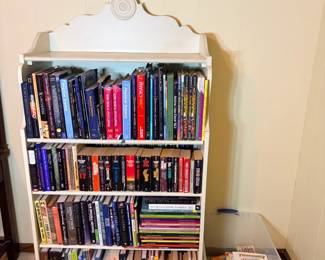 Astronomy and Science Book Library with Painted Bookcase - A substantial book collection heavy on astronomy and physics, including Carl Sagan's Pale Blue Dot, Stephen Hawking's On the Shoulders of Giants, Neil deGrasse Tyson titles, Seeing the Deep Sky, multiple editions of Discovering the Universe, and a run of National Geographic Society volumes. The lot also includes a full shelf of Stephen King paperbacks — It, The Stand, Christine, Skeleton Crew, The Talisman — and four Advanced Dungeons & Dragons hardcover manuals including the Dungeon Master's Guide and Players Handbook. The white painted bookcase and a tote of children's books are included. Condition is generally good with paperback reading wear. The AD&D manuals and the astronomy run each have their own dedicated collector base.