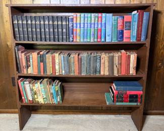 Antique Book Collection with Library of Entertainment Set and Wooden Shelf - This large antique book lot includes a twelve-volume Library of Entertainment set in embossed dark bindings, a numbered run of Collier's Junior Classics in colored cloth, and two shelves of vintage hardcovers including Ralph Connor's Black Rock, The Boy's King Arthur, and Fifty Years a Cowboy. Also present are a Funk & Wagnalls Standard Dictionary pair, The Literature of the United States, and a shelf of illustrated children's and outdoor titles. Condition varies widely across the lot — the older cloth-bound volumes show shelf wear, faded spines, and several with split or detached hinges. The brown painted bookshelf is included. A solid antique book lot for booksellers, decorators, and vintage library display.