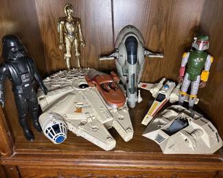 Vintage Star Wars Toy Lot A Star Wars lot including a Millennium Falcon, Slave I, X-Wing fighter, Snowspeeder, and R2-D2, along with large-scale Darth Vader, C-3PO, and Boba Fett figures. The vehicles show play wear including scuffing and paint loss, and completeness of parts and accessories has not been verified. The large Boba Fett figure retains its cape and both arm pieces. A substantial vintage Star Wars group in one lot.
