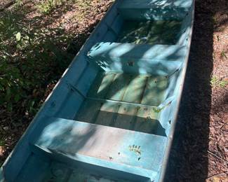 Aluminum Jon Boat A flat-bottom aluminum jon boat finished in a weathered blue-green paint, with bench seating and a squared transom. The hull shows exterior paint wear and weathering consistent with outdoor storage, and some debris and standing moisture are visible inside. The hull was not water-tested and seams were not inspected — condition not confirmed, sold as found. A practical lot for a farm pond, duck hunting, or anyone after an affordable small-water boat.