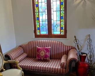 In this view, the central focus is on the red and white striped sofa, but more chairs are peeking into frame.