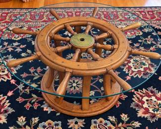 Ship's wheel coffee table above a traditional-style oriental area rug