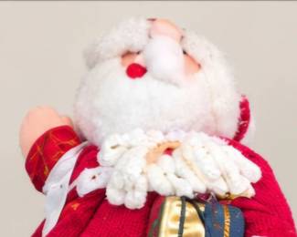 Large knitted Santa holding a gift.