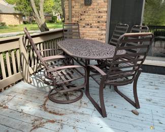 Outdoor wrought iron table with four rocker/swivel chairs plus 2 regular chairs. Measures 74” l x 42” w.