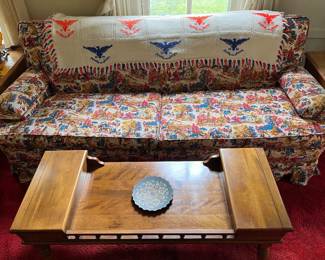Vintage upholstered sofa, blanket, and coffee table.