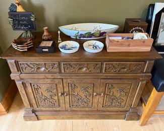 Ornate mid-to-late 20th-century Asian-inspired carved wooden cabinet or dry bar with intricate floral and foliage relief panels.