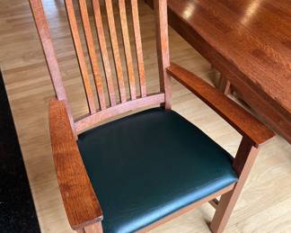 Closer view of one of the chairs for the mission-style rectangular wooden dining table paired with matching slat-back chairs.