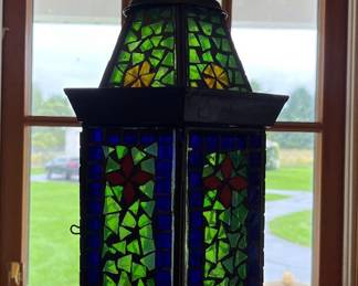 Hanging metal lantern with stained glass panels.