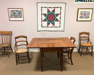 Drop leaf table and several of many chairs. Some of several wall hangings.