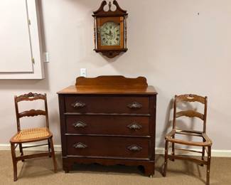 Dresser, clock, and two of many chairs.