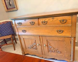 Oak buffet. One of several roseback chairs in corner.