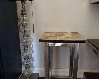 Vintage Glass Table Lamp & Chrome Bone-Tile Accent Table  Distinctive vintage table lamp featuring a sculptural column of stacked clear glass elements with an aged metal finish and pull-chain details. A unique decorative piece with wonderful vintage character.  Also shown is a sleek chrome accent table with a genuine bone-tile top, combining a polished geometric metal base with individually tiled natural bone in warm tonal variations.  Lamp and table are sold separately.