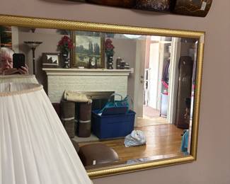 Mirror in living room with metal arrangement above