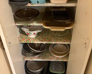 Bottom portion of cabinet includes ice trays, baking pans, bowls, white & strawberry strainer, muffin pans and more!