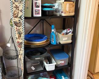 Paced closet type area full of plastic ware, hand blenders, plates, and much more!