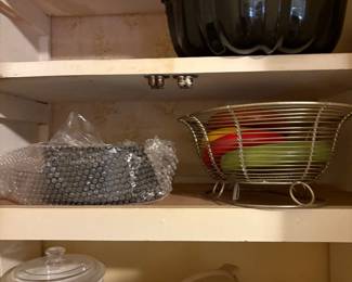 Corner cabinet to left of refrigerator- cake pan, metal container Corning ware with lids, plastic items