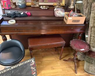 Large picture of piano, piano stool, and small table