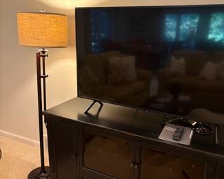 Another view of the media console and TV and floor lamp