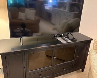 Black media console cabinet and large screen TV