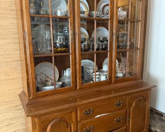 Maple china cabinet with arched glass doors and drawer base
