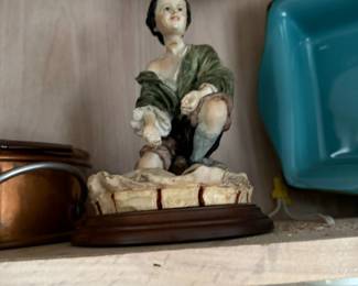 Porcelain figurine of seated peasant boy on wood base