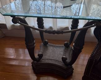 Glass top end table with ornate scrolled metal base