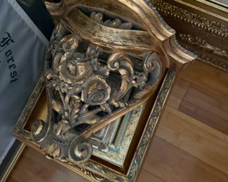Ornate gilt wood mirror with carved rose and scroll crest