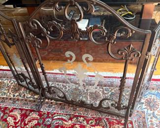 Ornate scrolled metal fireplace screen with etched glass panels