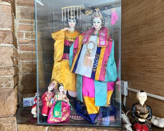 Korean hanbok dolls in silk robes under glass display case