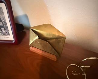 Brass envelope-shaped business card holder on wood base