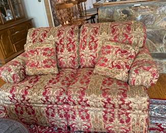 Loveseat sofa in red and gold damask upholstery with pillows